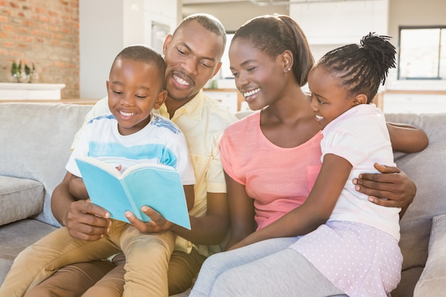 Gelukkige familie die een boek samen in woonkamer leest