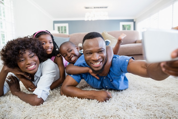 Gelukkige familie die een selfie van mobiele telefoon in de woonkamer