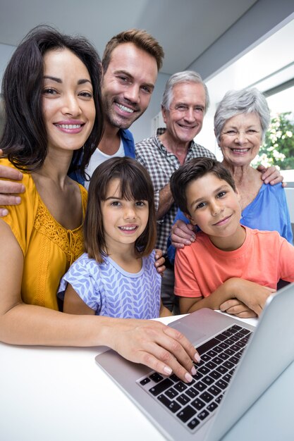 Gelukkige familie die gebruikend laptop op elkaar inwerken