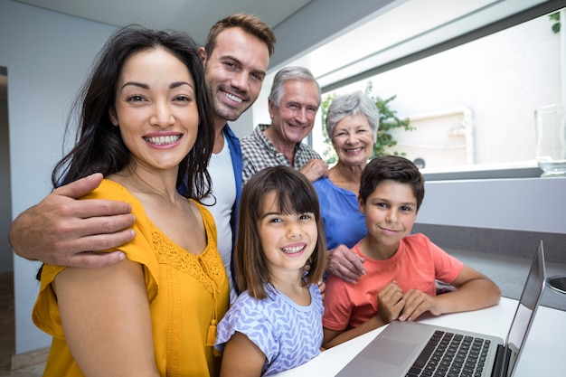 Gelukkige familie die gebruikend laptop op elkaar inwerken