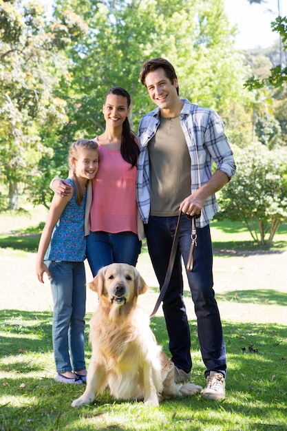 Gelukkige familie die hun hond in het park loopt