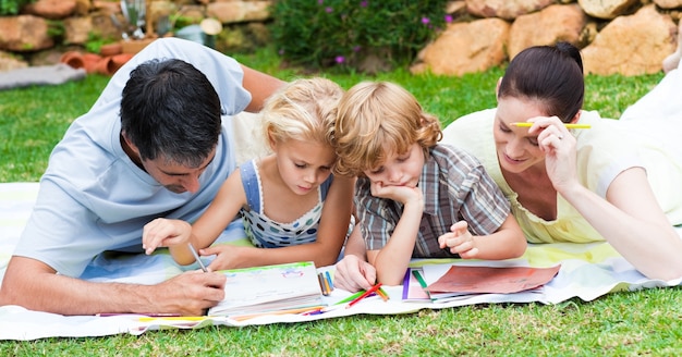 Gelukkige familie die in een park schrijft