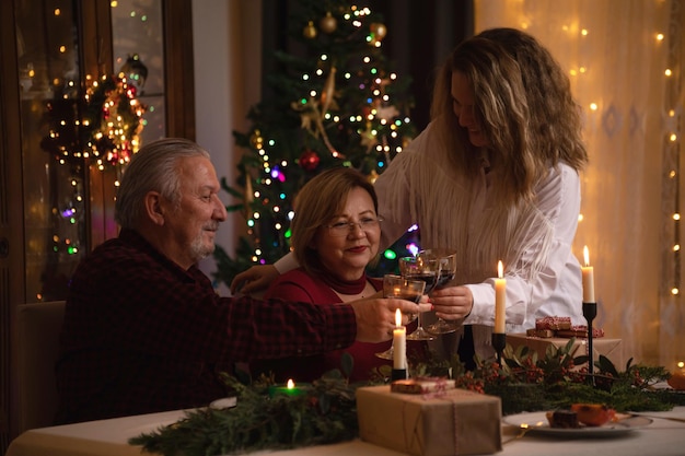 Gelukkige familie die Kerstmis thuis viert, plezier heeft, geniet van hun diner en samenzijn.