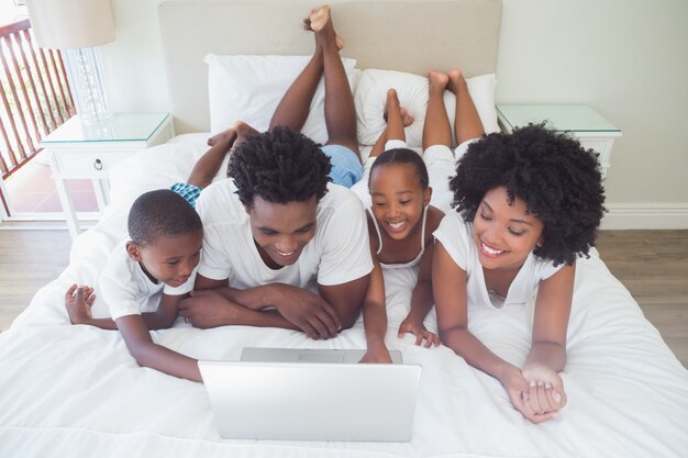 Gelukkige familie die laptop samen met behulp van