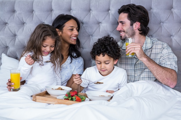 Gelukkige familie die ontbijt op bed heeft