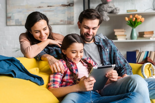 Gelukkige familie die op een tablet kijkt