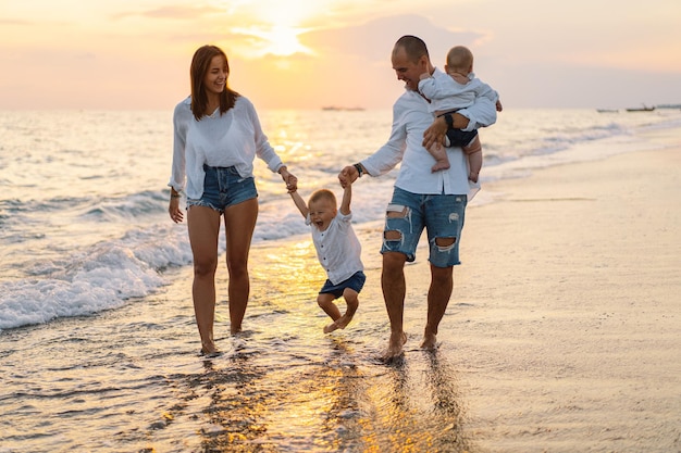 Gelukkige familie die pret heeft met strand spelen in de zomervakantie op het strand Gelukkige familie en vakanties concept Zeegezicht bij zonsondergang met mooie hemel Familie op het strand