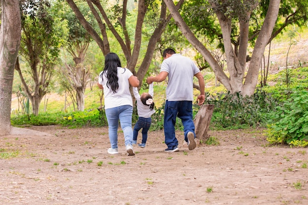 Gelukkige familie die 's middags door het park loopt, hand in hand