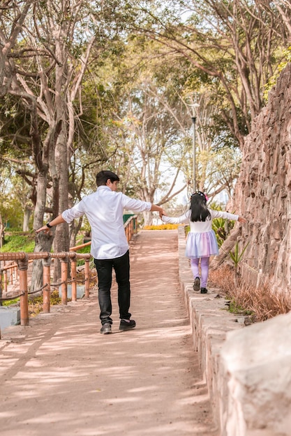 Gelukkige familie die 's middags door het park loopt, hand in hand