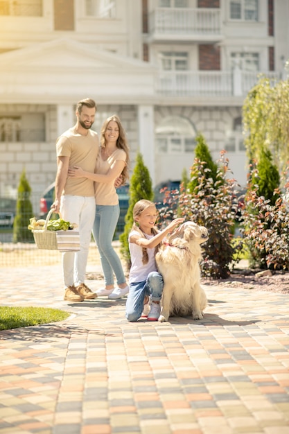 Gelukkige familie die samen met hun hond een wandeling maakt