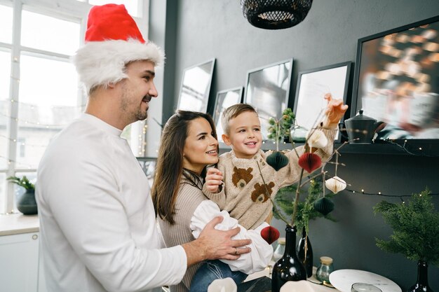 Gelukkige familie die samen thuis kerstversiering maakt