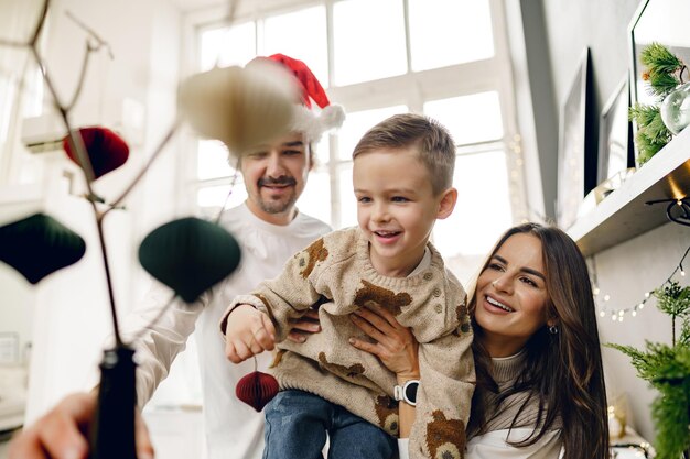 Gelukkige familie die samen thuis kerstversiering maakt