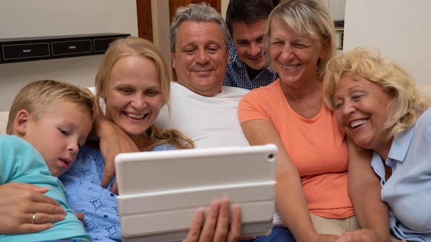 Foto gelukkige familie die thuis een film kijkt op een digitale tablet