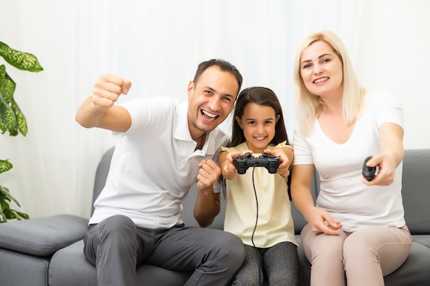 Gelukkige familie die thuis videogames speelt en samen plezier heeft.