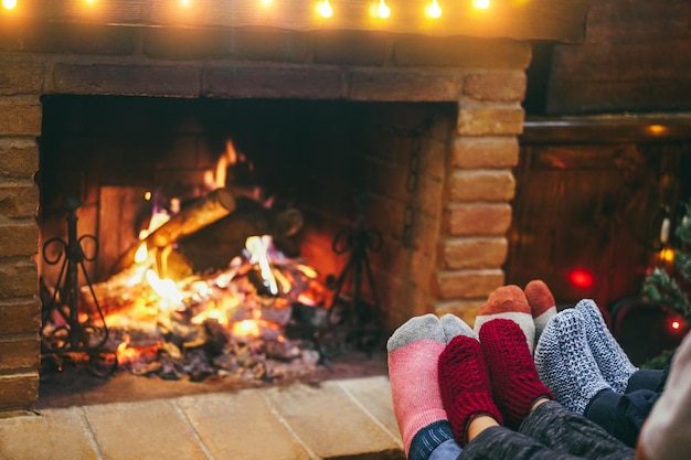 Gelukkige familie die warme sokken draagt voor de gezellige open haard tijdens de kerstperiode Focus op de juiste sokken