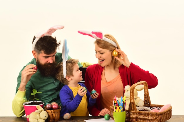 Gelukkige familie die zich voorbereidt op Pasen. Pasen-familie met kleur paaseieren op geïsoleerde achtergrond, ruimte voor tekst. Pasen familie bedrijf mand met beschilderde eieren.
