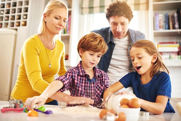 Gelukkige familie en bakken in de keuken met liefde om banden te ondersteunen teamwerk en leert wiskundige vaardigheden thuis moeder vader en kinderen met creativiteit leren en binden door samen koekjes te bakken