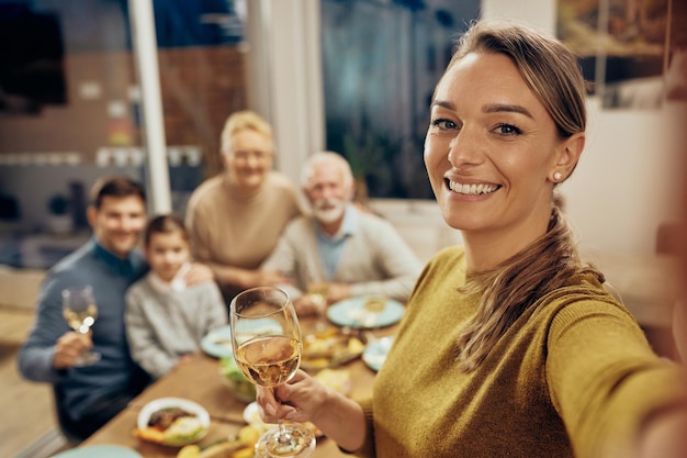 Gelukkige familie en haar uitgebreide familie nemen selfie tijdens de lunch in de eetkamer