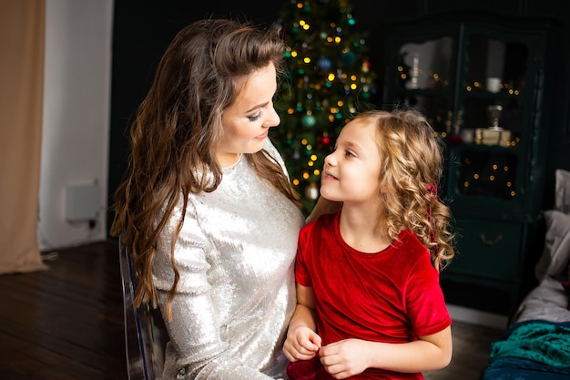 Gelukkige familie familie moeder en kind thuis in de buurt van de kerstboom