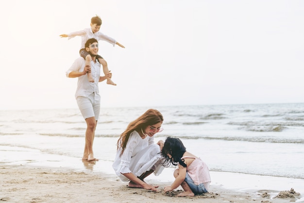 Gelukkige familie gaat vakantie op het strand in de zomer.