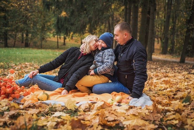 Gelukkige familie genieten van herfstpicknick. moeder vader en zoon.