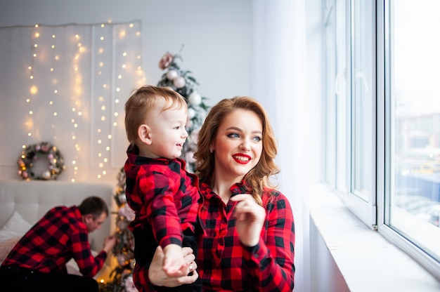 Gelukkige familie in de buurt van kerstboom in gezellig interieur