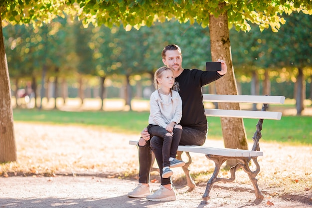 Gelukkige familie in de herfst. Vader en klein kind veel plezier met selfie nemen op mooie herfstdag