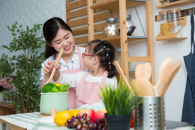 Gelukkige familie in de keuken. moeder en kind dochter bereiden van het eten.