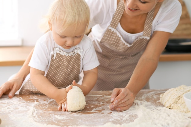 Gelukkige familie in de keuken. Moeder en kind dochter koken vakantie taart of koekjes voor Moederdag, casual lifestyle fotoseries in het echte leven interieur