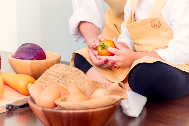 Gelukkige familie in de keuken. Moeder leert zoon om gezond voedsel te koken in de zomervakantie.