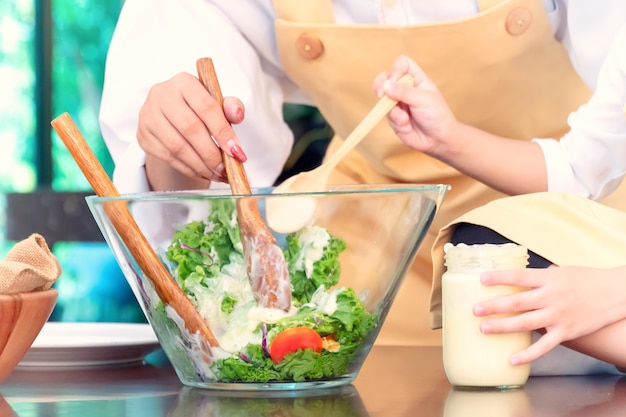 Gelukkige familie in de keuken. moeder leert zoon om gezond voedsel te koken in de zomervakantie.