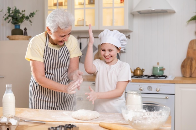 Gelukkige familie in de keuken oma en kleindochter koken samen in de keuken oma onderwijzen