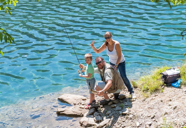 gelukkige familie is samen aan het vissen in de rivier op de berg
