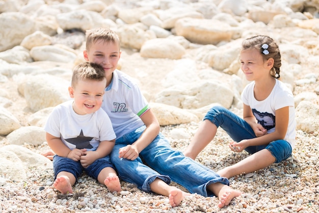 Gelukkige familie kinderen staan op een houten ponton voor de zee in de zomer.