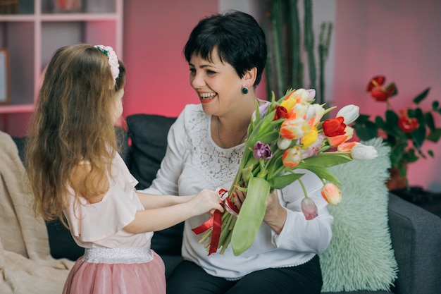 Gelukkige familie knuffelen. Gelukkige Moederdag. Dochtertje feliciteert haar moeder op Moederdag