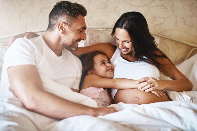Gelukkige familie lachen en slaapkamer voor zorg met steun jeugd zwangere moeder en liefde voor spelen mensen meisje en binding in het huis samen voor genegenheid als ouders voor weekend herinnering en emotie
