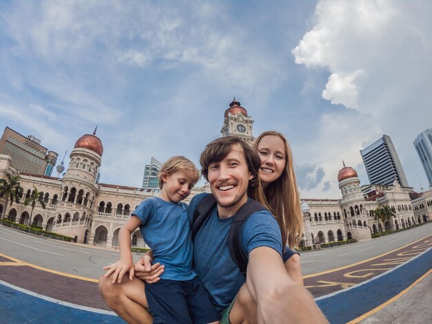 Gelukkige familie maakt selfie op de achtergrond op de achtergrond van merdeka square en sultan abdul samad