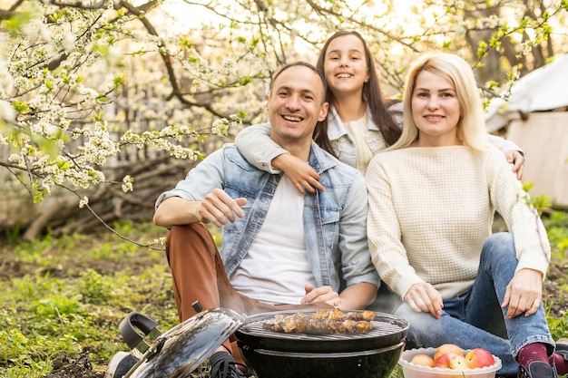 Gelukkige familie met barbecue met moderne grill buiten.