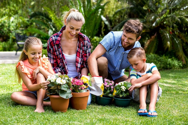 Gelukkige familie met bloempotten bij werf