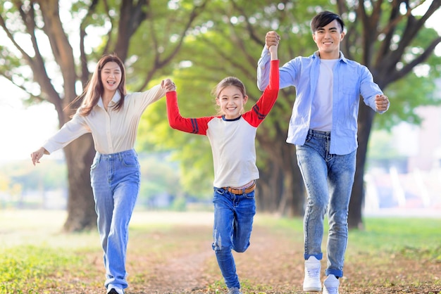 Gelukkige familie met dochter die samen rent en speelt in het park