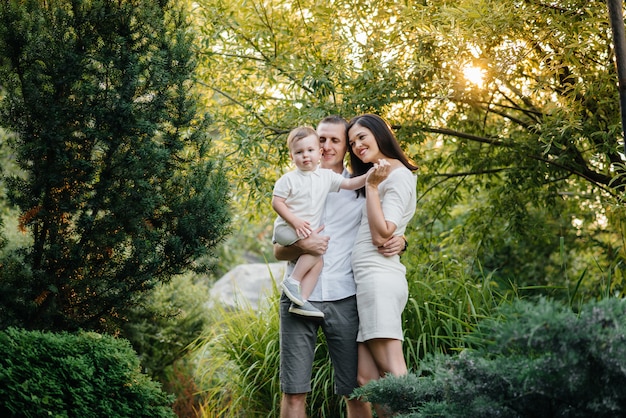 Gelukkige familie met hun zoon wandelen in het Park bij zonsondergang. Geluk. Liefde