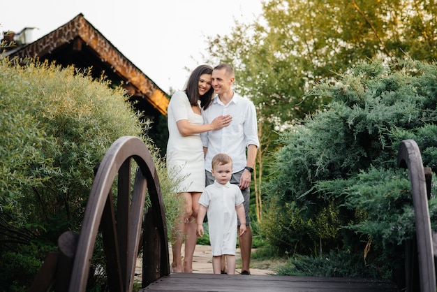 Gelukkige familie met hun zoon wandelen in het Park bij zonsondergang. Geluk. Liefde