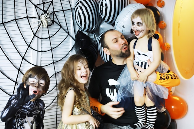 gelukkige familie met kinderen in kostuums en make-up op de viering van Halloween