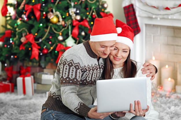 Gelukkige familie met laptop op kerstboom