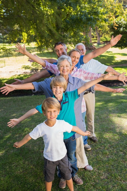 Gelukkige familie met uitgestrekte armen in het park