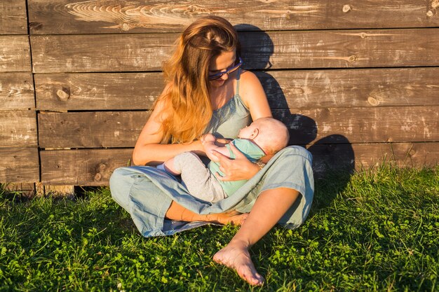 Gelukkige familie moeder en baby knuffelen op aard in de zomer
