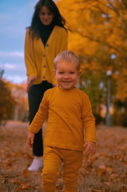 Foto gelukkige familie moeder en dochter spelen en lachen op de herfst lopen vallen