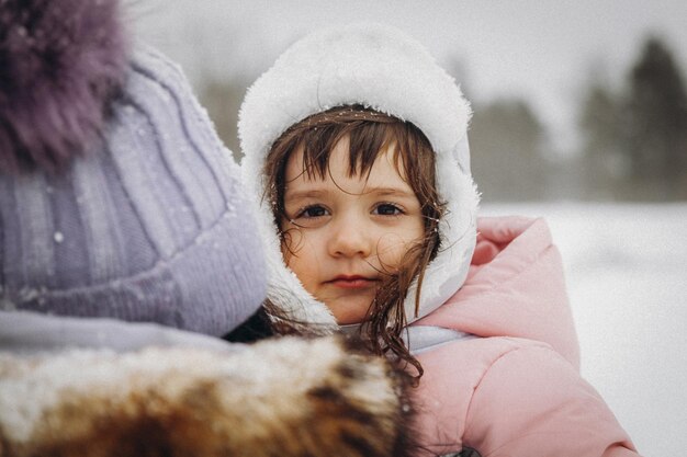 Gelukkige familie moeder en dochter veel plezier met spelen op winterwandeling buiten. winterportret van moeder en kind.