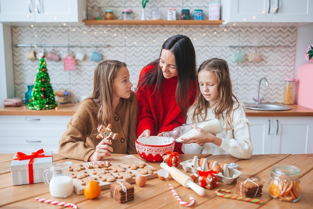 Gelukkige familie moeder en dochters bakken koekjes voor Kerstmis