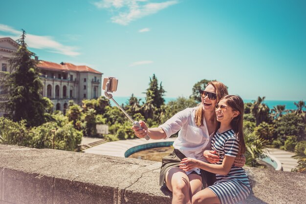 Gelukkige familie moeder en haar schattige dochtertje op zomervakantie nemen selfie met smartphone